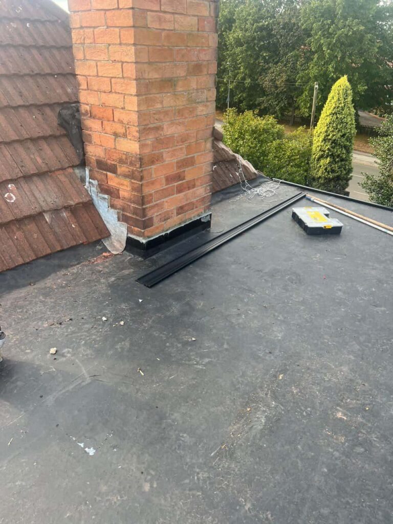 This is a photo of a flat roof which has just been repaired, there is also a chimney stack and some leadwork has also been dressed. Works carried out by Branston Roofing Repairs