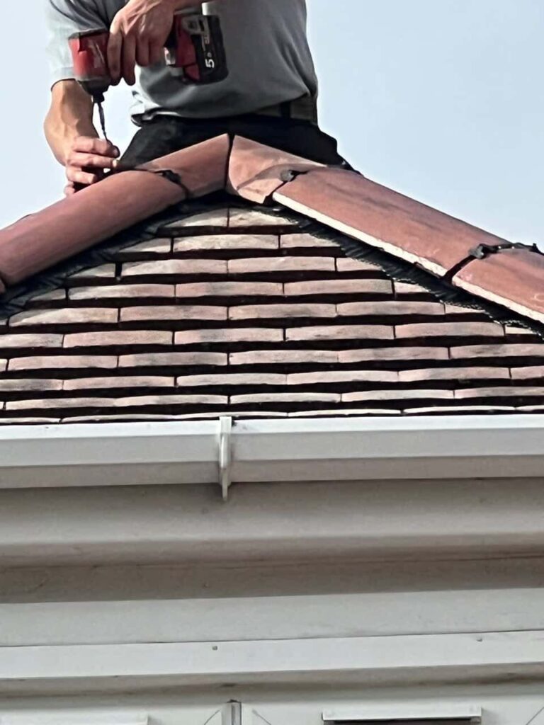 This is a photo of one of the operatives of Branston Roofing Repairs installing new ridge tiles